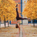 standing on hands during yoga practice on autumn street